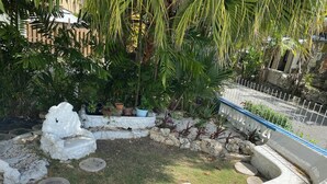 A garden with a stone pathway, potted plants, and a white fence. - Spacious 6-bedroom house in lovely Christ Church with WiFi, AC (Christ Church)