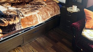 A bedroom with a wooden bed, orange walls, and a nightstand with a lamp. - Beautiful house for rent in front of the Illimani in the city of La Paz.  (El Alto)