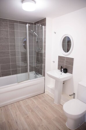 A modern bathroom with a glass-enclosed shower, a white sink, and a toilet. - Bankside , cozy luxury home away from home. Spectacular home with free parking (Banbury)