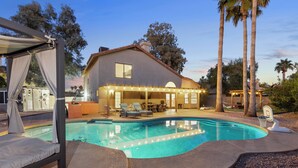A swimming pool with lounge chairs and a covered patio area. - Paradise Palms House with Resort-Style Backyard, Pool and Hot Tub (Scottsdale)