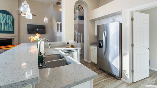 A modern kitchen with a granite countertop, stainless steel appliances, and pendant lighting. - Paradise Palms House with Resort-Style Backyard, Pool and Hot Tub (Scottsdale)