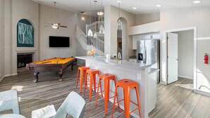 A modern kitchen with a central island, a pool table, and orange bar stools. - Paradise Palms House with Resort-Style Backyard, Pool and Hot Tub (Scottsdale)