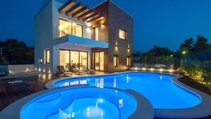 A modern two-story house with a swimming pool and outdoor seating area. - Beautiful villa Tamaria with heated pool and roof terrace (Zaton)