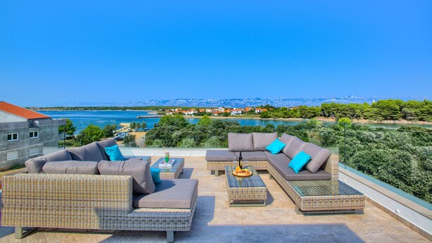 A rooftop terrace with wicker furniture, a view of a lake, and a mountainous landscape in the background. - Beautiful villa Tamaria with heated pool and roof terrace (Zaton)
