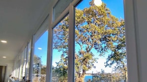 A long, narrow room with large windows and a white bench along the wall.