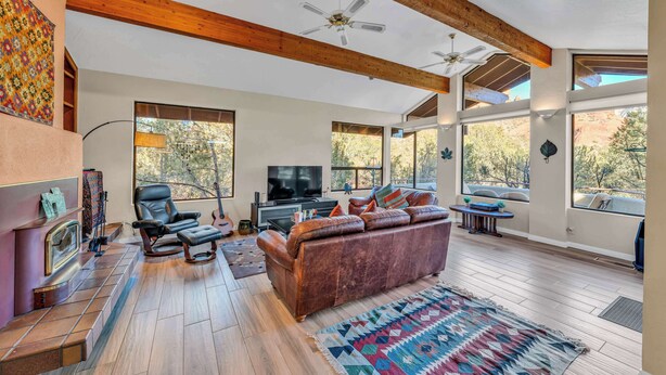 A spacious living room with a large leather sofa, a television, and a fireplace.