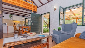 A cozy living room with a sofa, a wooden coffee table, and a dining area with a table and chairs.