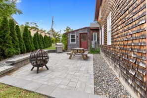 A patio with a fire pit, a picnic table, and a barbecue grill. - Cozy, open-concept, Parker River House. Waterfront, boat slip, pet-friendly! (Newbury)