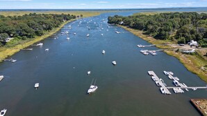 Una marina con numerosos barcos amarrados a lo largo de un río, rodeada de exuberante vegetación.