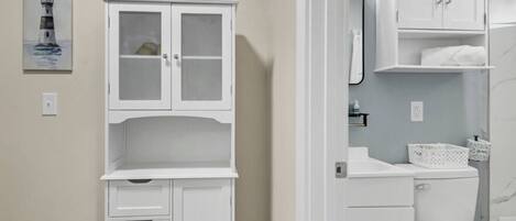 Un baño con un mueble blanco, un inodoro y un lavamanos.