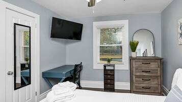 2 habitaciones, escritorio y tabla de planchar con plancha