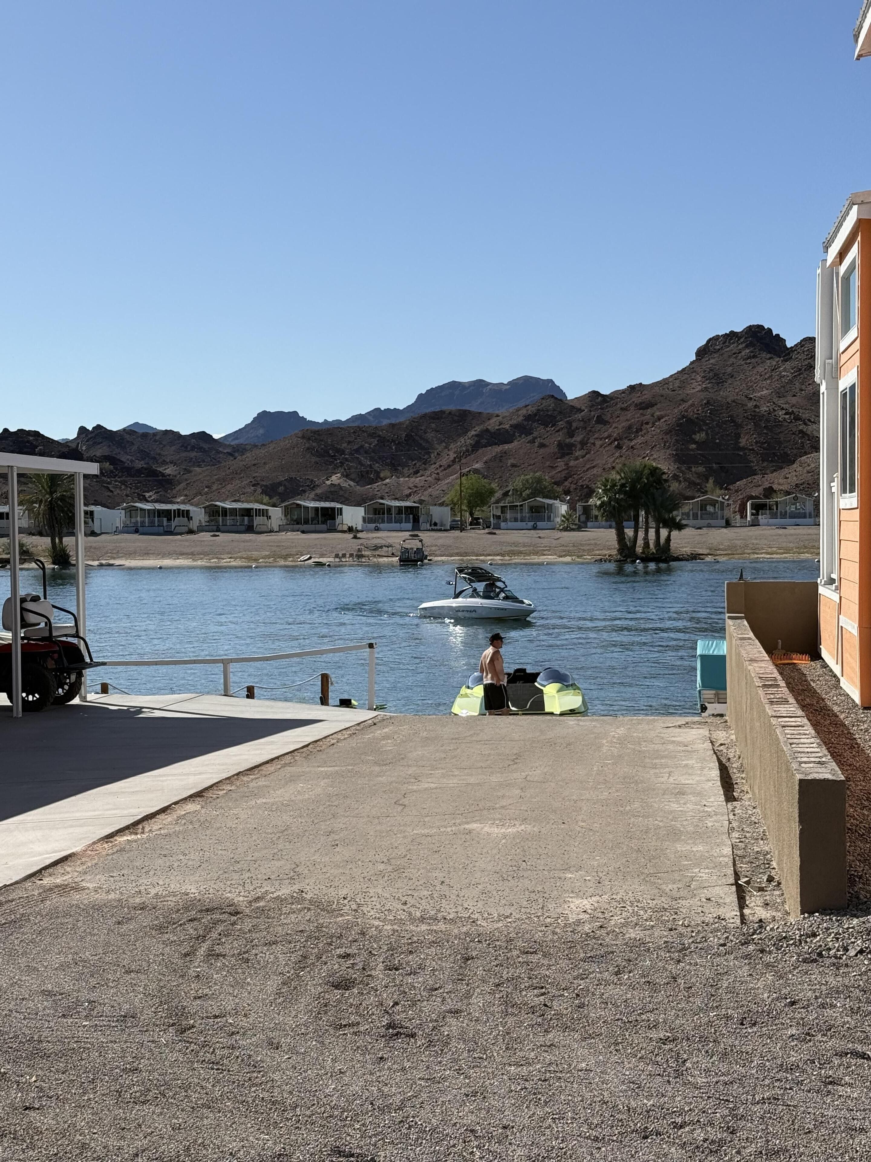 Un puerto deportivo con barcos, un jet ski y una persona en traje de baño.