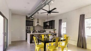 A modern kitchen with a central island, yellow chairs around a table, and a ceiling fan. - Nova-400k Backyard! Old Town and Ent District! (Scottsdale)