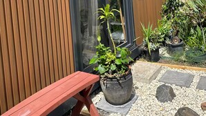 A modern house with a wooden exterior, a sliding glass door, and a small garden area with a bench and potted plants. - Beach Serenity 1

Share

Save
 (Brighton-Le-Sands)