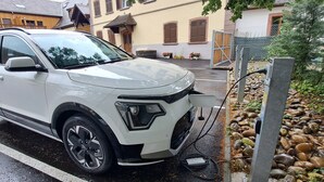 A white SUV parked on a wet street with a charging station nearby. - The Cozy Nest, Le Nid Douillet à Bergheim (Bergheim)