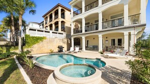 Un edificio de dos plantas con piscina y zona de estar exterior.