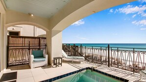 A balcony with a pool, lounge chairs, and a view of the beach. - 🌊 Serenity by the Sea | Beach Front | FREE Pool Heating | Elevator & FREE Excursions (Miramar Beach)
