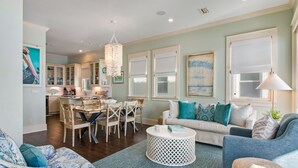 A spacious living room with a dining area, a kitchen, and a large window with a view. - 🌊 Serenity by the Sea | Beach Front | FREE Pool Heating | Elevator & FREE Excursions (Miramar Beach)