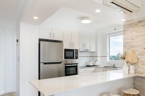 Apartamento superluxo, sacada, vista para o oceano | Cozinha privada | Cafeteira/chaleira, chaleira elétrica, torradeira, produtos de limpeza