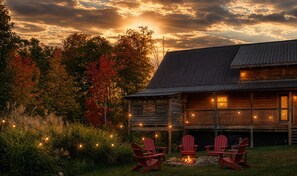 A rustic cabin with a porch, outdoor seating, and a fire pit.