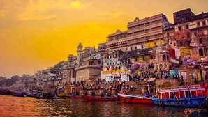A riverside view with boats and buildings along the shore. - Shiv Kashi P Guest House By Glitz Hotels (Varanasi)
