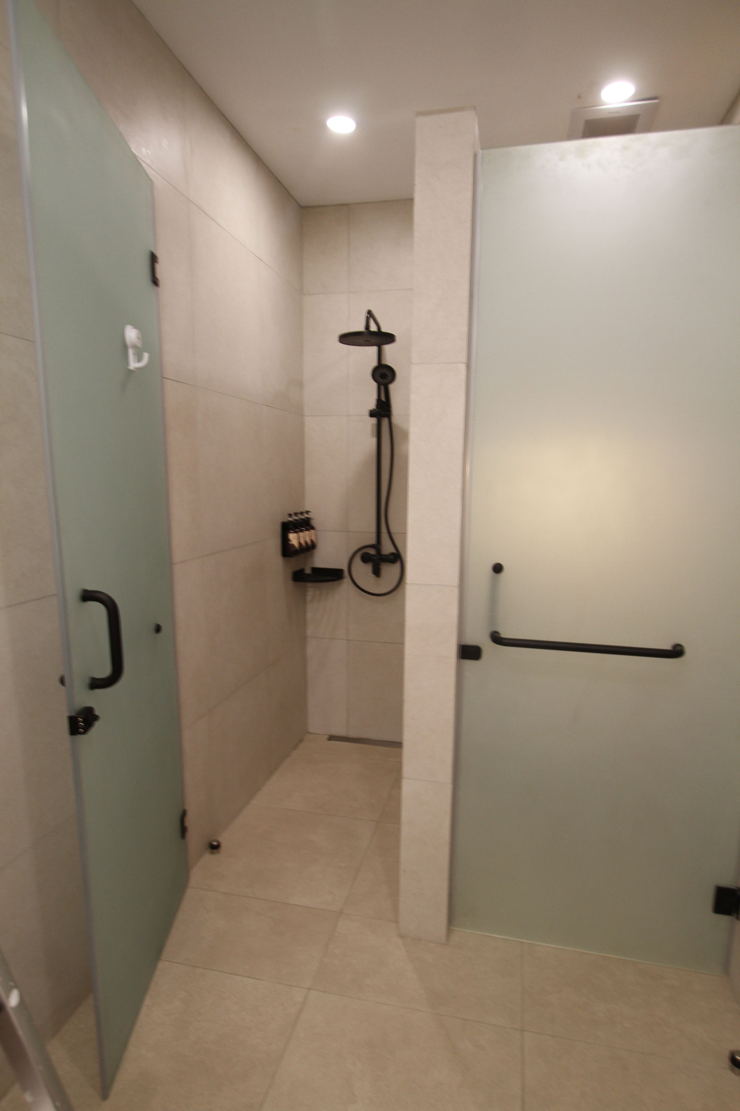 A bathroom with a shower, a toilet, and a sink.