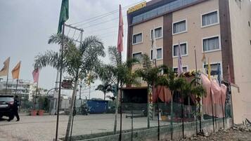 A multi-story building with a modern facade, a fenced outdoor area, and several flags.