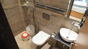 A bathroom with a toilet, bidet, sink, and a mirror.
