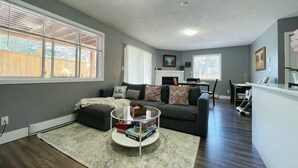 A living room with a grey sofa, a coffee table, and a fireplace.