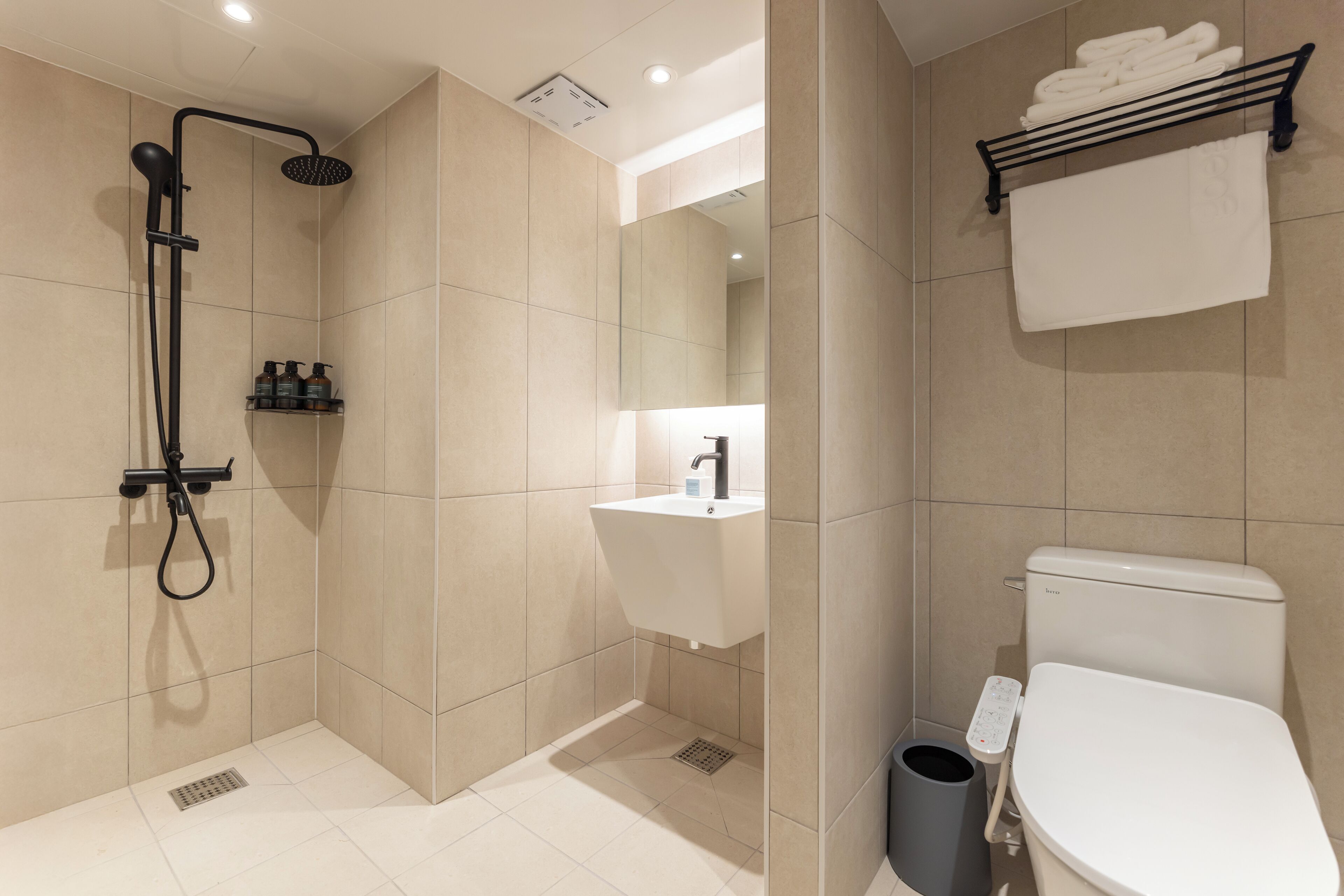 A modern bathroom with a walk-in shower, a toilet, and a sink.