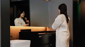 A modern bathroom with a large mirror, a white sink, and black cabinetry. - Anook Hotel Yeongdengpo (Seoul)