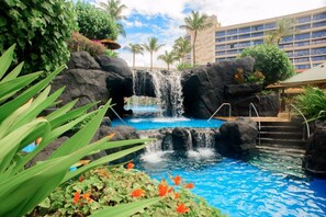 A pool area with a waterfall, surrounded by tropical plants and palm trees. - Maui Resort Rentals: Marriott's Maui Ocean Club Studio Mountain/Gardenview Suite (Lahaina)