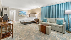 Ein Hotelzimmer mit Bett, Sofa, Schreibtisch und Lampe.