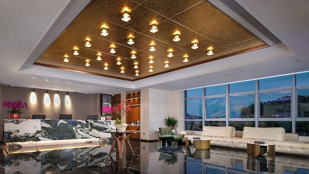 A modern lobby with a marble reception desk, seating area, and large windows offering a view. - Guangzhou Tianwei Hotel  (Guangzhou)