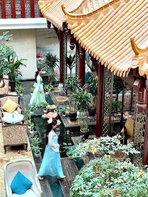 A traditional courtyard with a tiled roof, potted plants, and seating areas. - Cynn Hotel Chengdu (Chengdu)