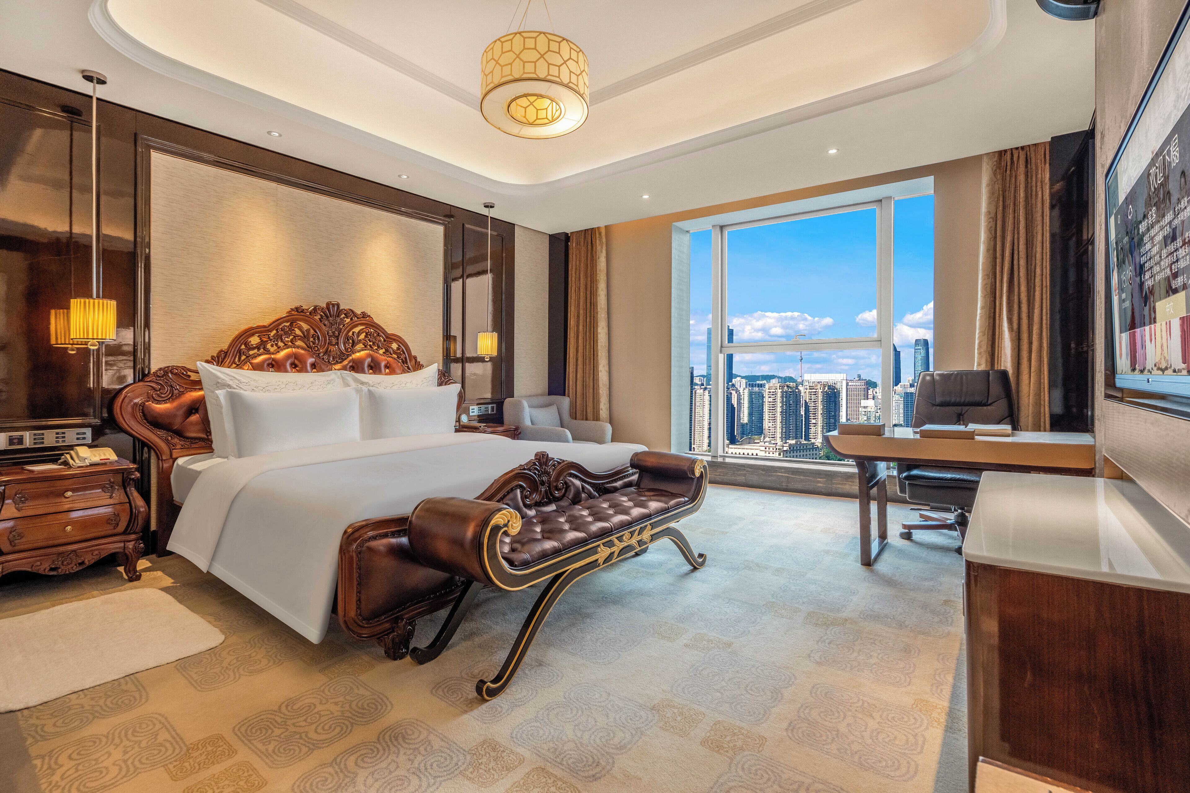 A spacious hotel room with a large bed, a desk, and a view of the city.