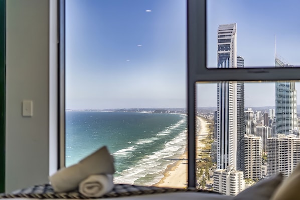 A view of a beach and high-rise buildings through a window.