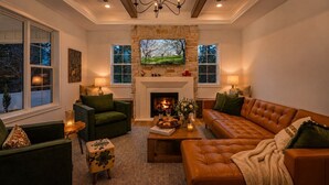 A cozy living room with a fireplace, comfortable seating, and a large window. - Luxury Meets Location | Near Ephraim & Sister Bay (Ephraim)