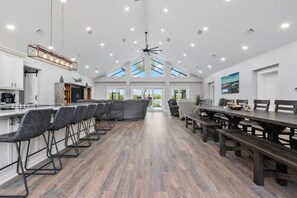A spacious kitchen with a long counter, multiple chairs, and a dining area with benches. - Spacious Lake Tarpon Getaway (Palm Harbor)