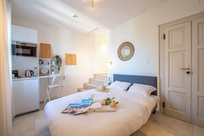A hotel room with a bed, a desk, a microwave, and a staircase. - Tesori della Vetta Pervinca, Lugano, Switzerland (Lugano)