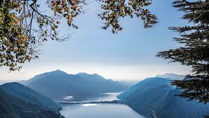 A panoramic view of a lake surrounded by mountains, with a clear sky above.
