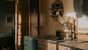 A kitchen with wooden cabinets, a sink, a vintage blue refrigerator, and a wall-mounted shelf with kitchenware. - Holiday Home 'Stall Und Sterne' with Mountain View, Shared Terrace and Wi-Fi (Hirschfeld)
