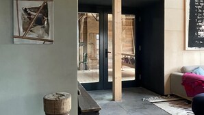 A modern interior with a wooden ceiling, a framed abstract painting, a wooden stool, and a blackboard with text. - Holiday Home 'Stall Und Sterne' with Mountain View, Shared Terrace and Wi-Fi (Hirschfeld)