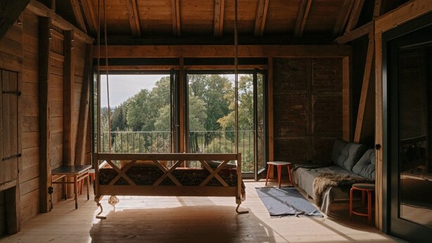 A wooden interior with a bench, a sofa, and a large window. - Holiday Home 'Stall Und Sterne' with Mountain View, Shared Terrace and Wi-Fi (Hirschfeld)