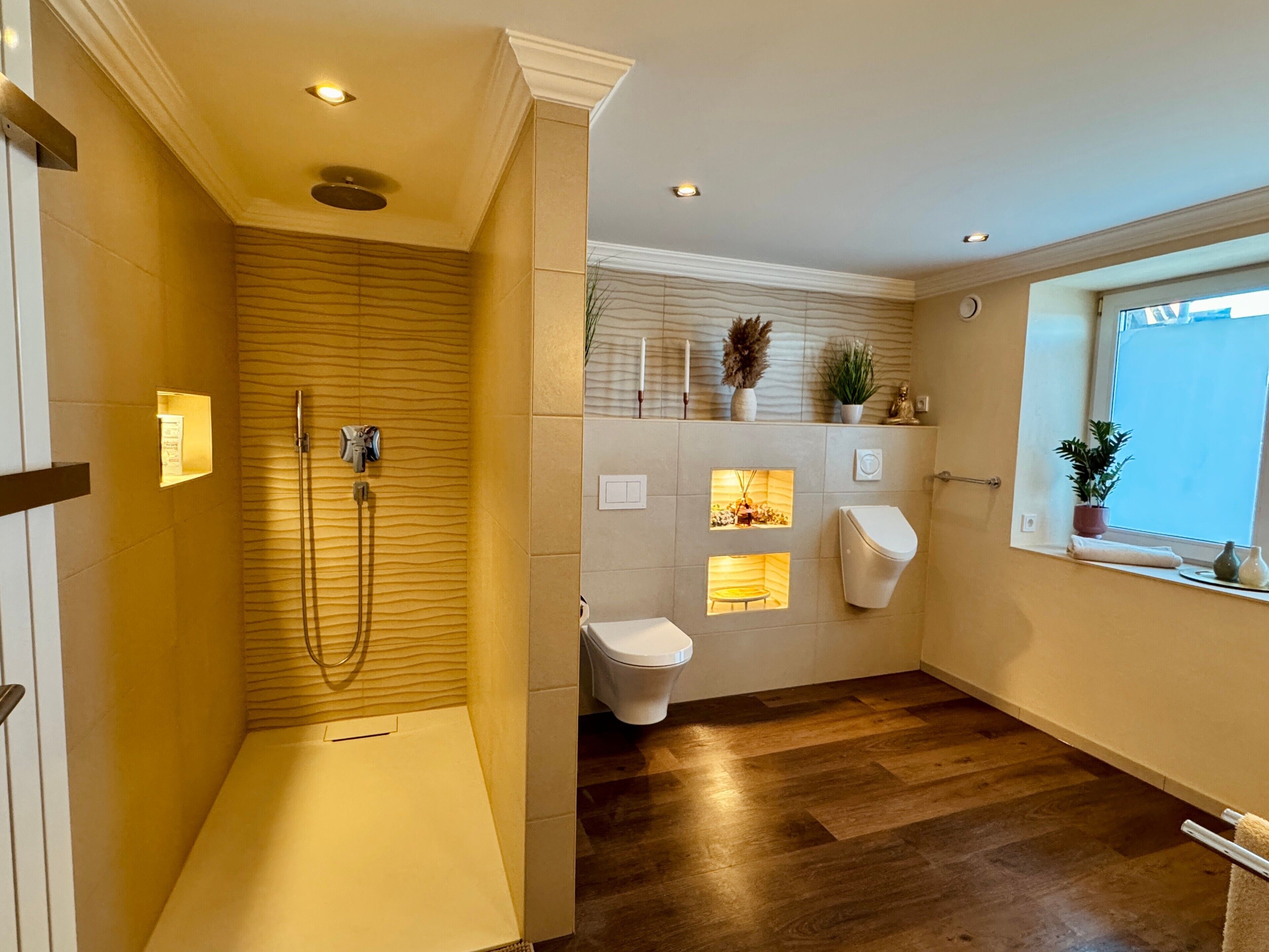A modern bathroom with a walk-in shower, a toilet, and a window with a view.