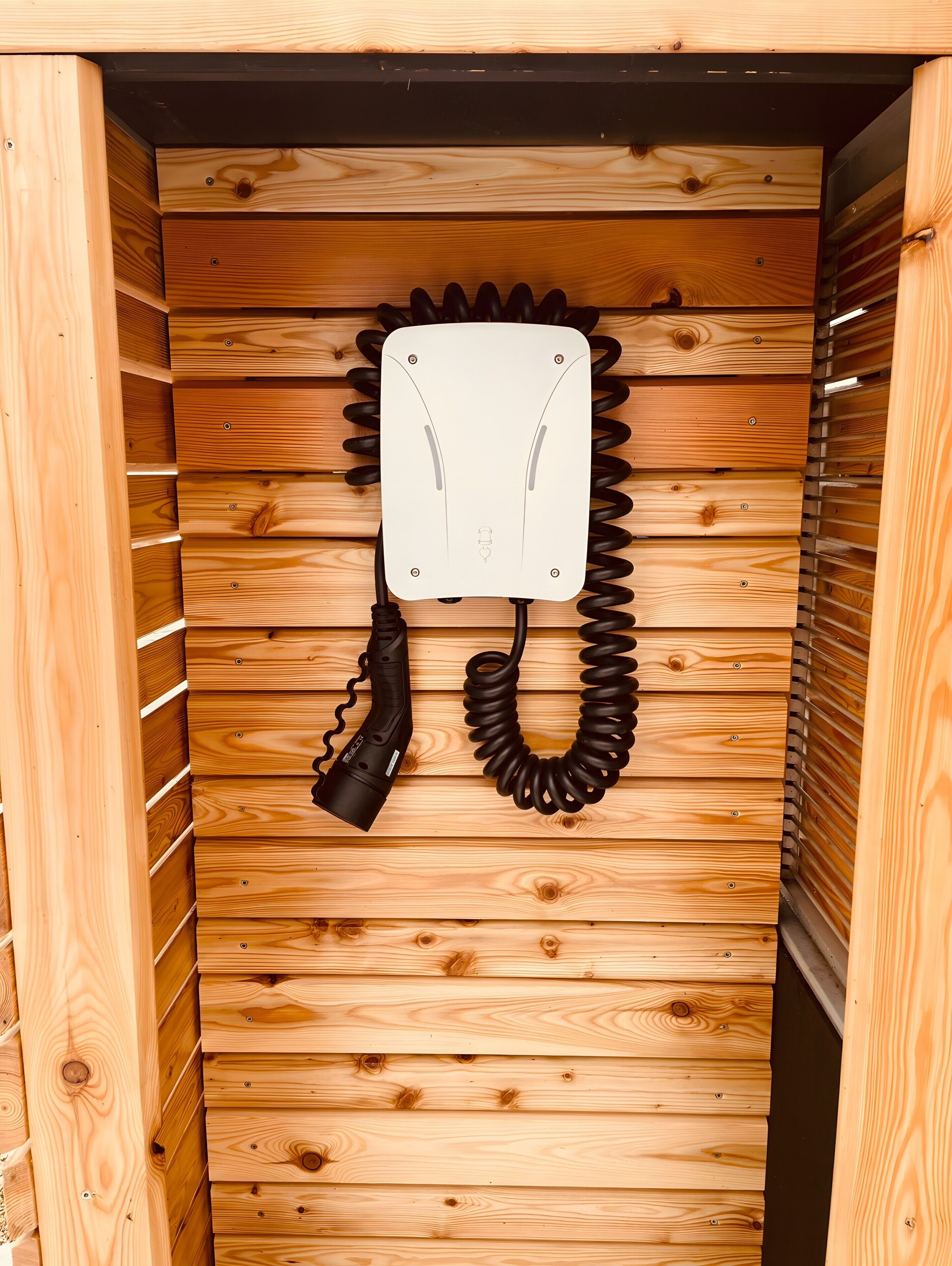 Un interior de madera con un teléfono enrollado y un panel blanco.