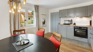 Eine moderne Küche mit grauen Schränken, einer schwarzen Arbeitsplatte und einem eingebauten Backofen.