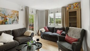 Ein modernes Wohnzimmer mit zwei Sofas, einem Couchtisch und einem Bild an der Wand.