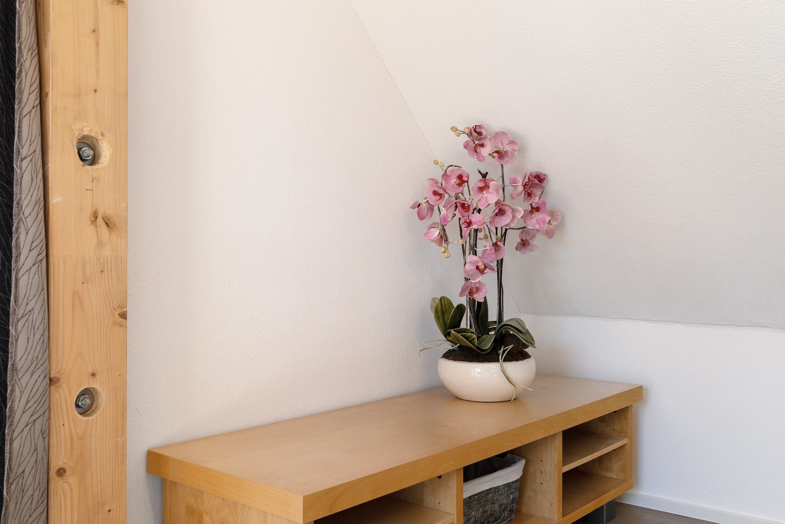 Eine Holzbank mit einem Topf-Orchideenpflanze.
