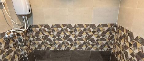 Un baño con bañera, dispensador de jabón para manos y azulejos con diseño en las paredes.
